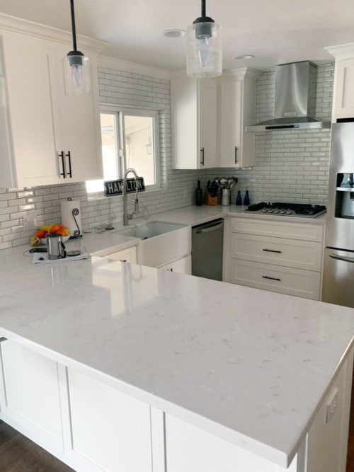 Kitchen remodel with white subway backsplash and white cabinets